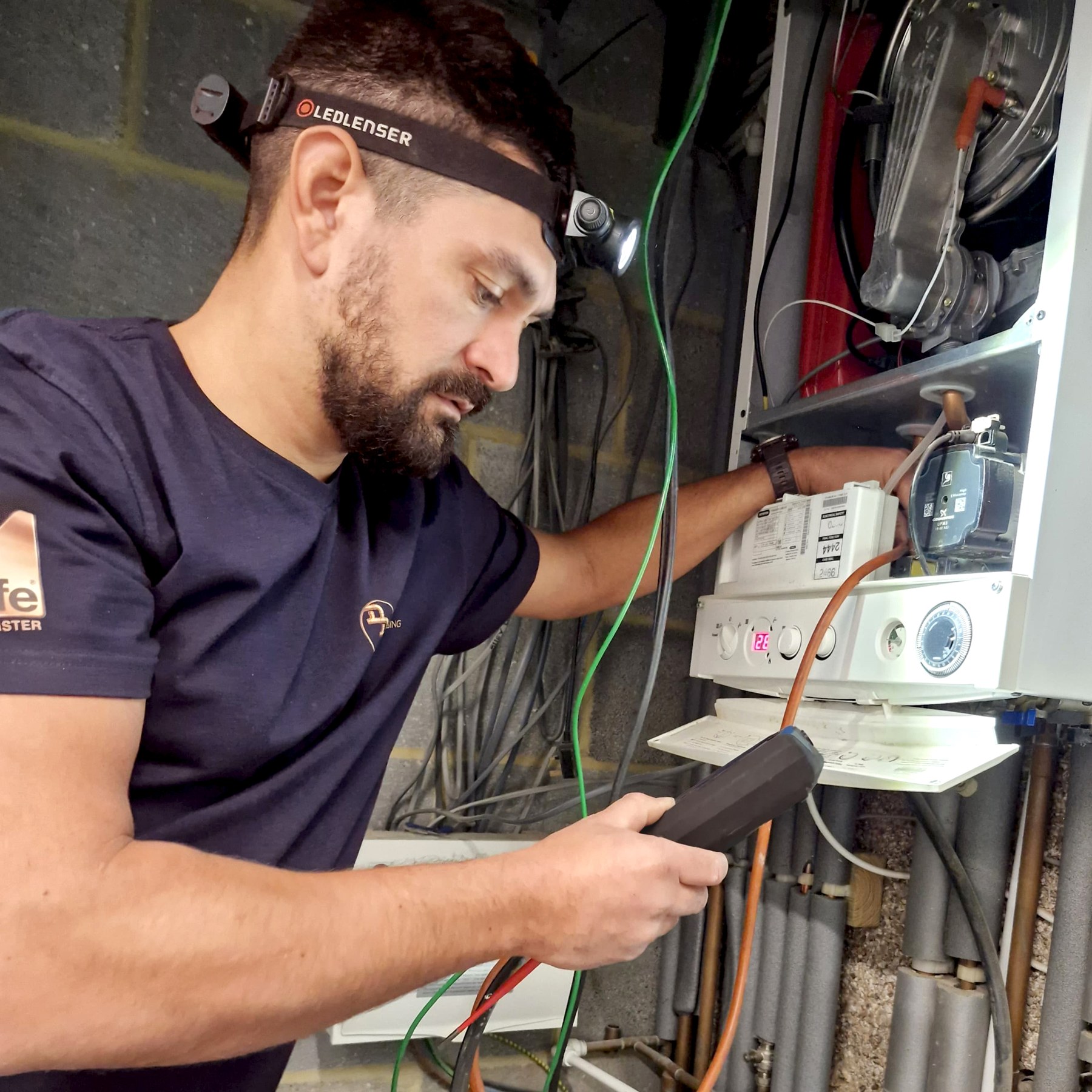 The owner of Daniel David Plumbing working on a boiler